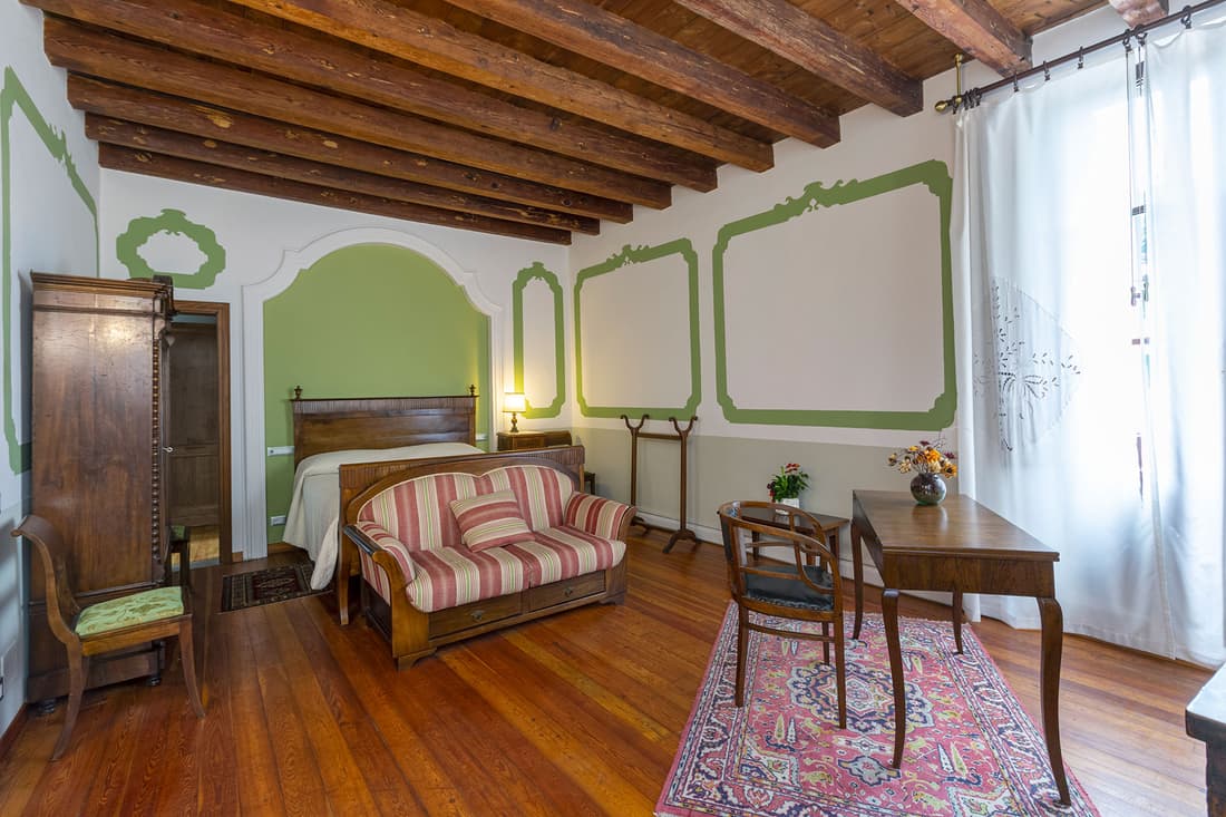 Suite Livenza, con travi a vista e cornici verdi dipinte